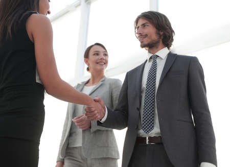 Businesspeople  shaking hands against room with large window looの写真素材