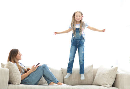 little girl jumping on the couch on the couch in the living room