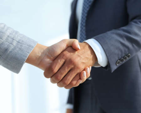 Excited smiling businessman handshaking partner at meeting,の写真素材