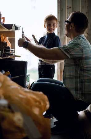 father and son work together in the home workshopの写真素材