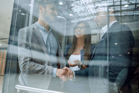 colleagues shaking hands in the Elevato