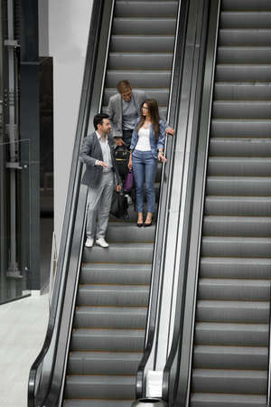 business people standing on the escalator