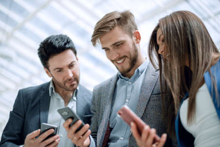 close up.business colleagues reading a text on smartphones