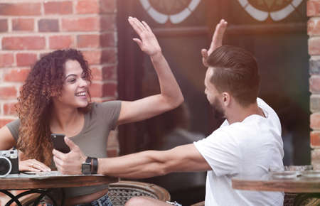 Portrait of a young  couple sitting down at a cafe outside