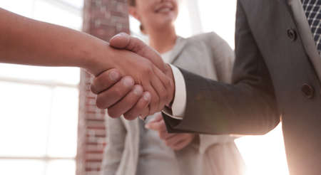 Businesspeople  shaking hands against room with large window looの写真素材