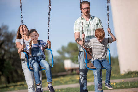 couple with two children playing in the Playgroundの写真素材