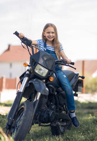 little girl driving a motorcycleの写真素材