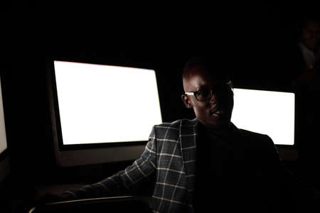 young businessman sitting in computer room at nightの写真素材