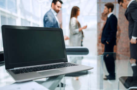 laptop with blank screen on table in modern office.