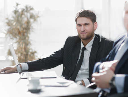 successful businessman with his colleague sitting behind a Desk.
