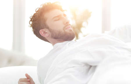 closeup.tired man sleeping on the bed.の写真素材