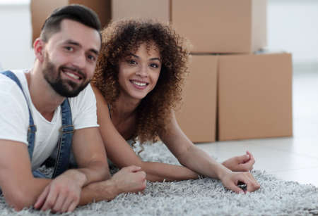 Happy couple lies on the floor in a new apartment