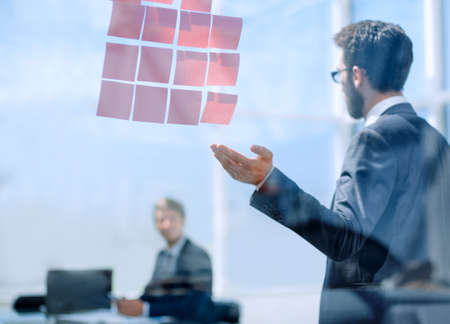 Manager pointing at the glass office Boardの写真素材