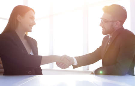 Friendly smiling business people  handshaking after pleasant talk