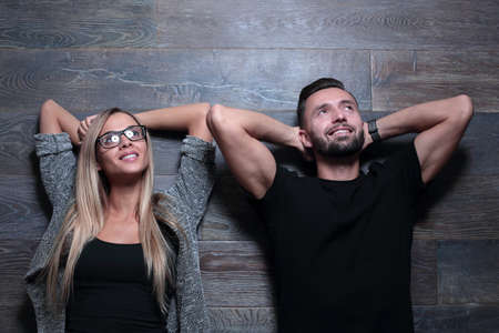woman and man stand near the wall and gesture with their hands