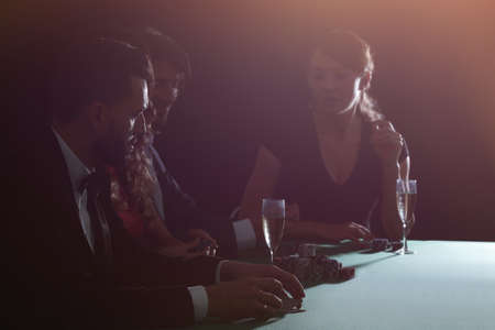 side view of group of people playing poker together in casino