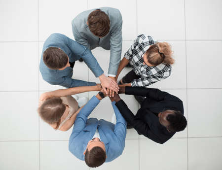Top view of people putting hands together