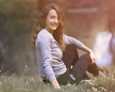 young woman sitting near the river