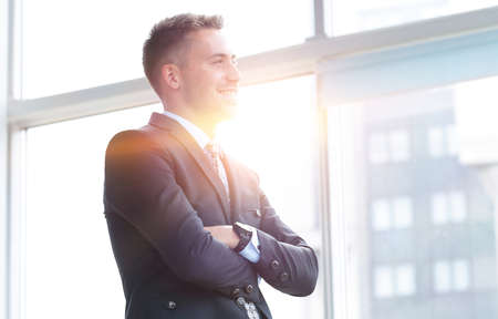 portrait of confident businessman looking out the window of the office.の写真素材