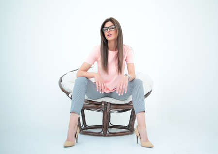 modern young woman sitting in a round chair.