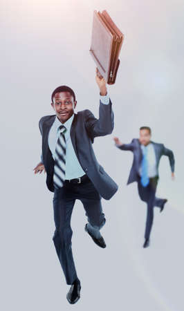 Happy afroamerican man running with a briefcase in hand. in the background- his colleague, trying to...