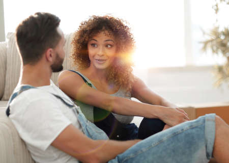 Newlyweds sitting on the couch in a new apartment.