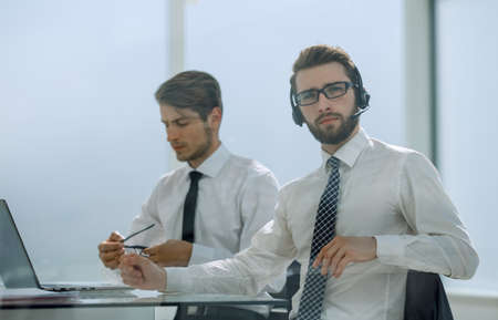 Manager with the headset works in a modern officeの写真素材