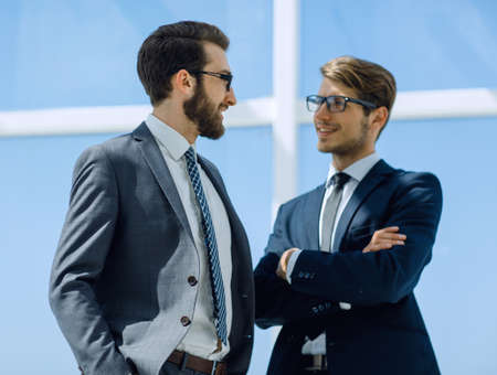 two thoughtful business partner standing near the office windowの写真素材