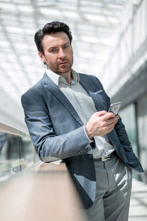 businessman with smartphone standing in the airport building