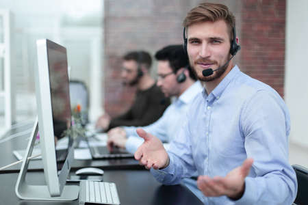 friendly staff with a headset in the workplace in the business centerの写真素材