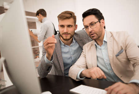 two businessmen look at the computer monitorの写真素材
