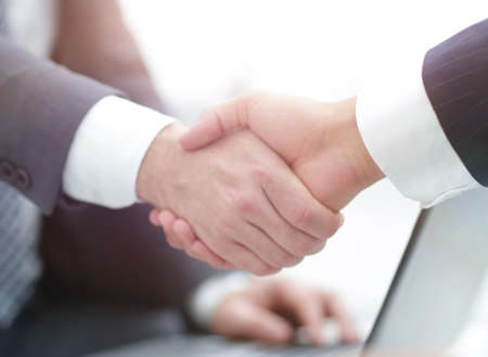 Closeup of business people shaking hands over a dealの写真素材