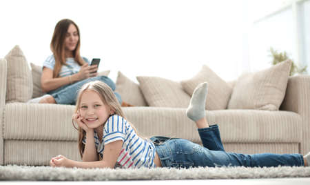 mom and her daughter are resting in the new living roomの写真素材