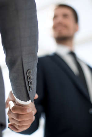 young businessman in glasses shakes hands with his colleague. view from belowの写真素材