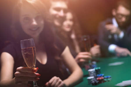fashion woman with glasses of wine,sitting at a table in a casinoの写真素材