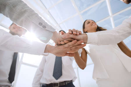close up. a group of employees putting their hands together
