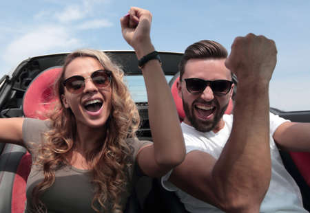 close up.a happy couple travelling in a convertible.