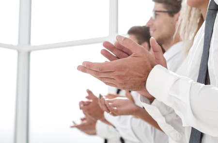 business team applauds standing in a bright officeの写真素材