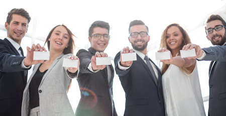 group of young entrepreneurs showing their business cardsの写真素材