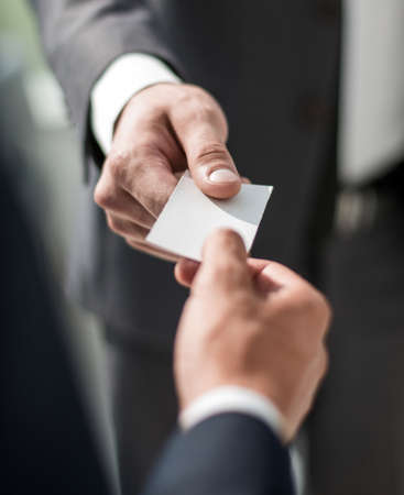 close up.business partners exchanging their business cards