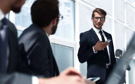 businessman with a smartphone standing in his ofiiceの写真素材