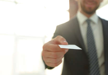 Business man giving business card on bright backgroundの写真素材