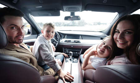close up.smiling family sitting in a comfortable carの写真素材
