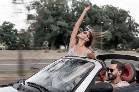 newlyweds enjoying a trip in a convertible.