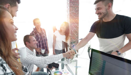 handshake of colleagues in a creative office.