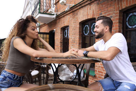 Trendy young couple drinking coffee cafe outsideの写真素材