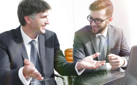 Portrait of two business people sitting at office desk