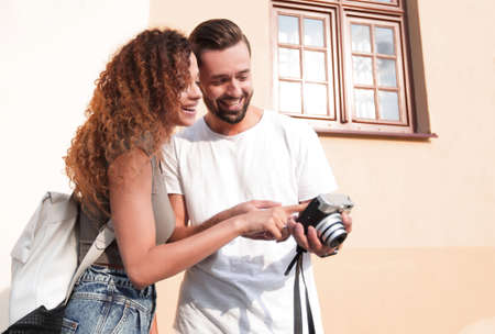 Portrait of young friends walking looking at the photosの写真素材