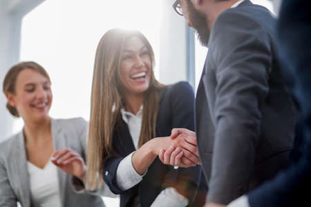 close up.smiling business woman shaking hands with partnersの写真素材
