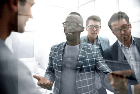 behind the glass. a group of business people talking in the office